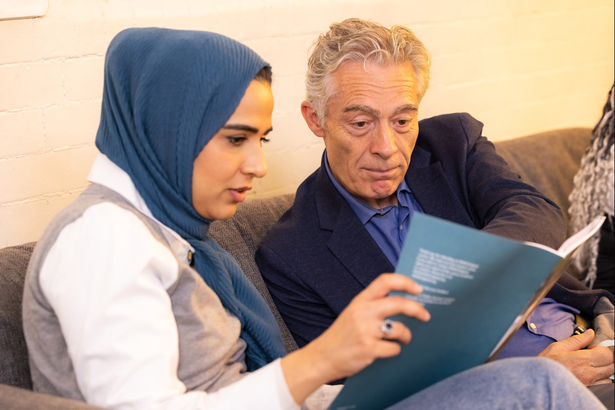 A female and male looking at a publication 