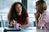 Two Women Talking At A Desk