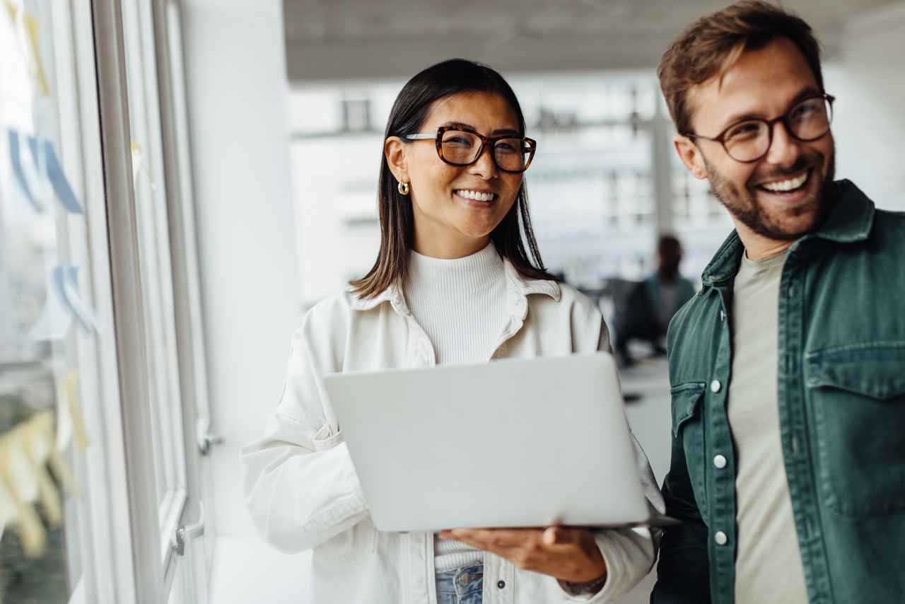 Business Woman Holding A Laptop And Standing With Colleague