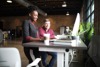 Two People Looking At A Screen