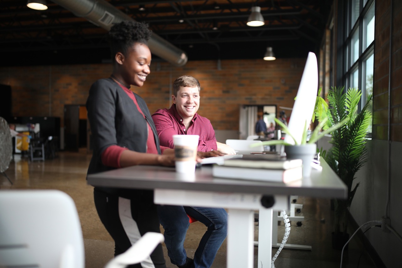 Two People Looking At A Screen