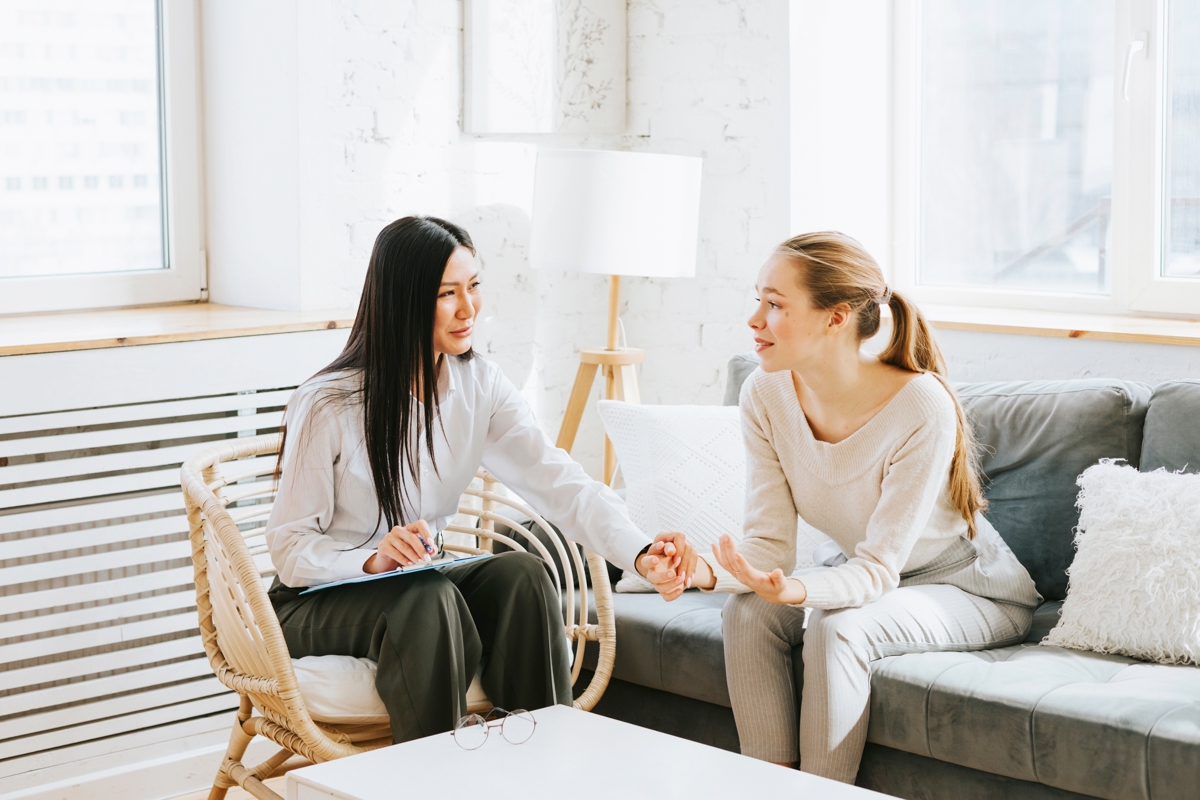 Two Women Sitting Down Facing Towards Each Other