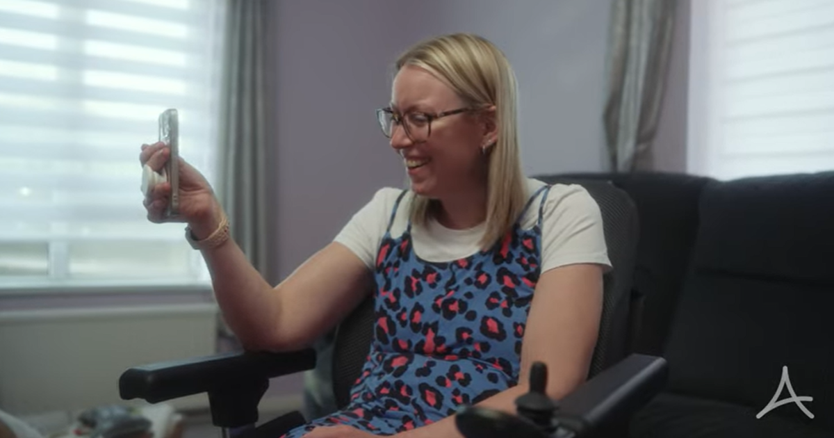 A Lady Smiling In A Wheelchair