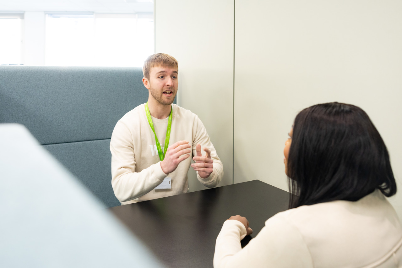 Two People Speaking At A Table (1)